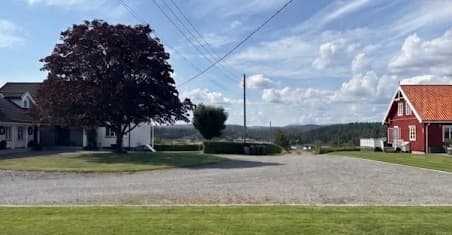 Tunet på Haughem Gård med hovedhuset og et rødt gårdshus